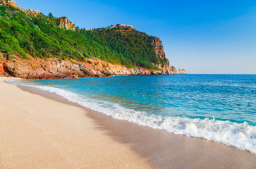 Wall Mural - Cleopatra beach with beautiful sand and green rocks in Alanya peninsula, Antalya district, Turkey, Asia. Famous tourist destination with high cliff and ancient old Castle. Summer bright day