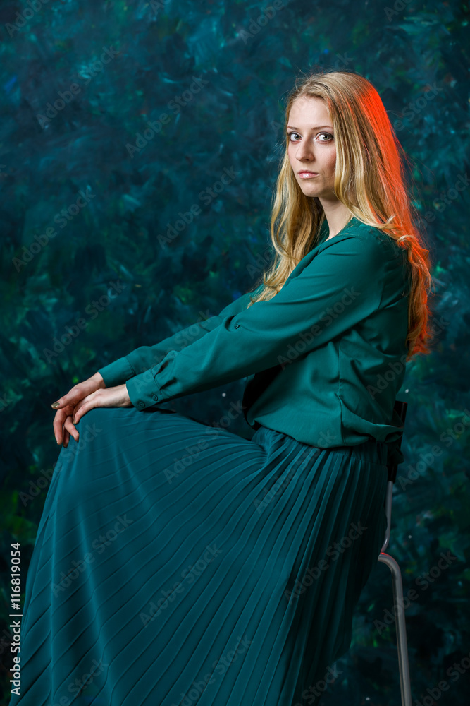 blonde girl on a green background in a long green dress - obrazy, fototapety, plakaty 