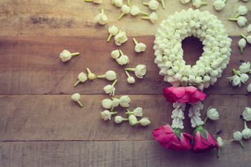 Thai traditional jasmine garland On wooden background symbol of Mother's day in thailand, to offer the monk or buddha.