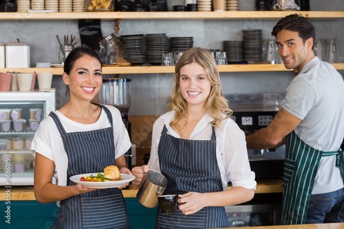 Fotomural Portrait of smiling colleague working at counter