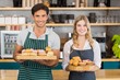 © WavebreakmediaMicro - Portrait of waiter and waitress holding a tray of cupcakes