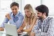 © WavebreakMediaMicro - Smiling woman and two men using laptop