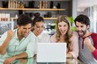 © WavebreakMediaMicro - Group of excited friends using laptop