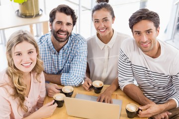 Wall Mural - Group of friends using laptop while having cup of coffee