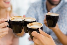 Group Of Happy Friends Toasting Cup Of Coffee