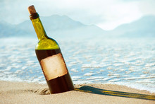 Alcohol Bottle With Old Paper Label In The Sand On A Tropical Beach. Space For Text Title Alcohol