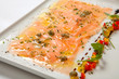 Salmon carpaccio on a white plate decorated with vegetables. Seafood Carpaccio - Salmon Carpaccio