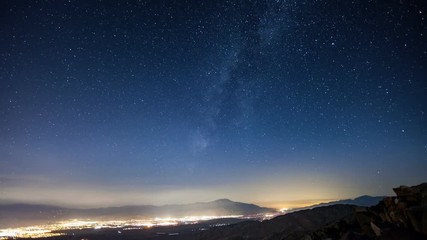 Wall Mural - Time-lapse of the night sky. The Lights of Palm Springs California can be seen in the distance.