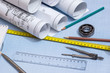rolls of engineering drawings with tools on graph background