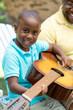 © digitalskillet1 - African American man teaching his son how to play the guitar