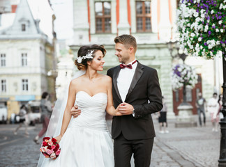 Married couple in the city holding bouquet