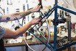 © Mint Images - Man working in bicycle repair shop