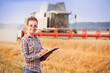 © favorestudio - Pretty farmer girl in glasses with hair tied in a ponytail keeps a harvest accounting in the folder. Sunny day. Horizontal. Image released. Image released.