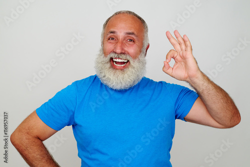 Fotografie, Obraz Aged man with white beard and broad smile showing OK gesture