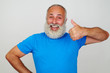 Smiling man with white beard showing thumbs up gesture against w
