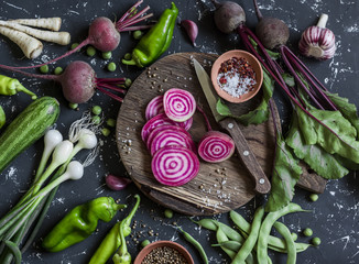 chopped beets, peppers, onions, green beans, spices on a dark background. fresh garden vegetables. v