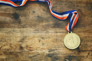Wall Mural - top view image of gold medal over wooden table