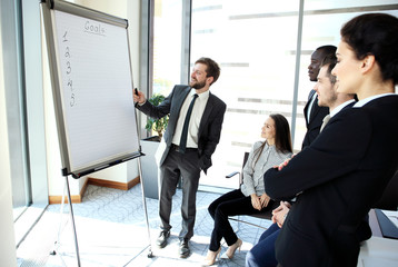 Canvas Print - Cheerful businessman discussing new business project with the members of his team