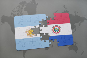 puzzle with the national flag of argentina and paraguay on a world map background.