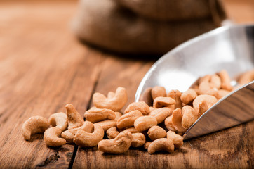 Wall Mural - cashew nut in sack scoop on wood table