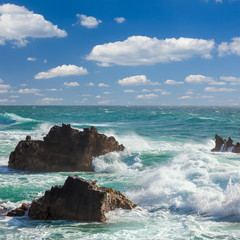 Wall Mural - Turquoise ocean waves,  rocks coastline and  blue sky