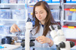 Female Teenage Student In Science Class With Experiment, Young Woman Student In Science Class With Microscope end Microscope slide