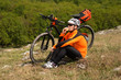 © Aleksey - Active man sitting on bike and eating sandwich