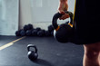 © baranq - Closeup of kettlebell held by athlete at the gym