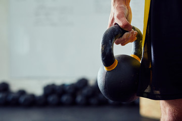 Wall Mural - Closeup of kettlebell held by men at the gym