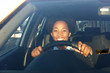 © mimagephotos - Young african woman driving a car and smiling