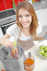 Wall Mural - Beautiful girl making juice in kitchen