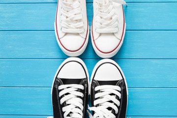 Two pairs of canvas shoes on a blue wooden