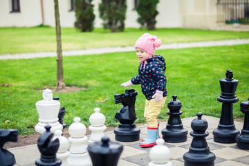 girl playing with giant chess