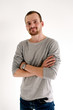 © danilkorolev - Confident young man with beard and arms crossed looking at camera