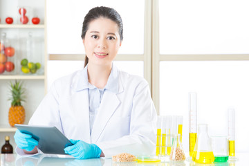 Canvas Print - Asian female scientist touch the digital tablet holding soya bea