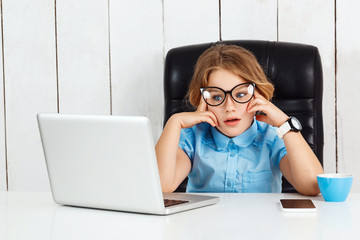 Tired young beautiful girl sitting at working place in office.