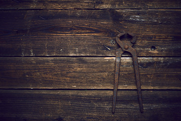 Wall Mural - old rusty tongs on wooden boards background