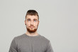 © Cookie Studio - Young handsome man posing over grey background. Copy space.