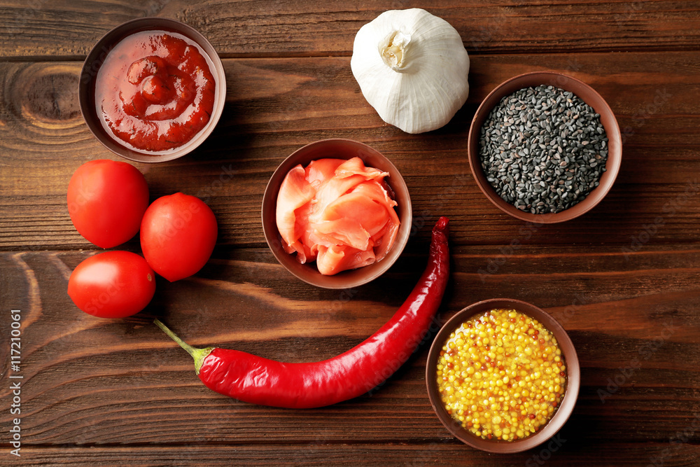 Fresh seasoning and sauce on wooden background