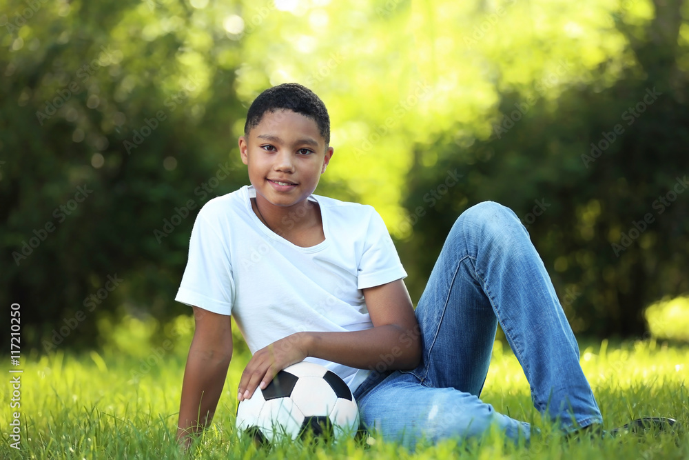 African American boy with soccer ball in park