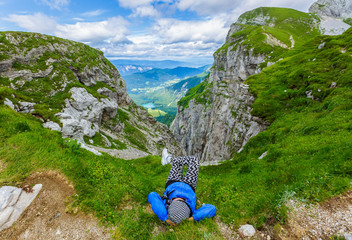 People from behind, female person enjoying on mountain with beautiful landscape of green scenery and blue sky clouds