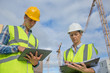 © eric - business, building, paperwork and people concept - builder in hardhat with tablett outdoors
