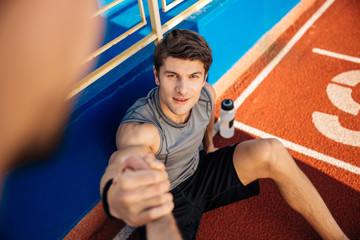 Wall Mural - Fitness man with water bottle needs help at the stadium