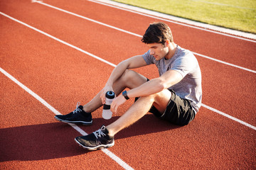 Sticker - Young handsome man athlete resting with water bottle