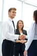© ASDF - Happy business partners shaking hands in an office