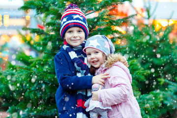 Wall Mural - Two little smiling kids, boy and girl with christmas tree