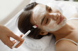© puhhha - Facial Beauty Treatment. Beautiful Woman Getting Cosmetic Mask