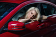 © alex_m_bronco - Beautiful blond sitting in a red car, looks thoughtfully into the mirror.