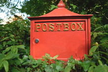 Red Postbox Surrounded By Plants