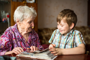 Wall Mural - Grandma shows photo album to little grandson.